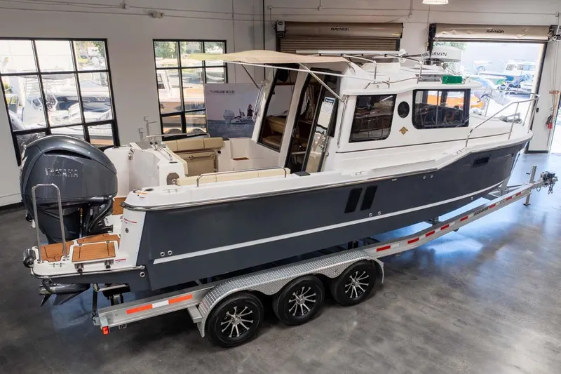 Slide: The Image of 2025 Ranger Tugs R-25 boat on trailer in showroom setting. - 4