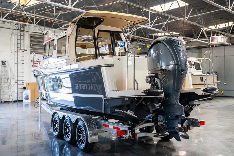 Slide: The Image of 2025 Ranger Tugs R-25 boat on trailer in a spacious indoor facility. - 6