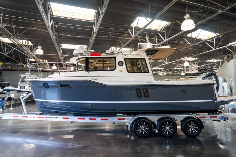 Slide: The Image of 2025 Ranger Tugs R-25 boat on trailer in indoor showroom setting. - 7