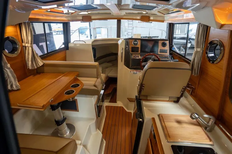 Slide: The Image of Interior of 2025 Ranger Tugs R-25 boat with wood accents and modern helm. - 9