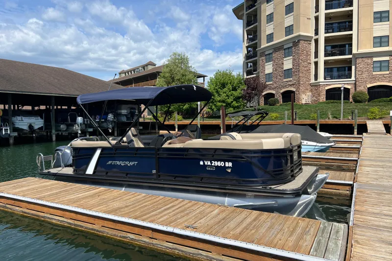The Image of 2026 Starcraft EXS 3 R DH pontoon boat docked at marina, sunny day. - 0