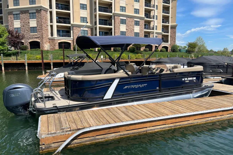 Slide: The Image of 2026 Starcraft EXS 3 R DH pontoon boat docked by waterfront apartments. - 1