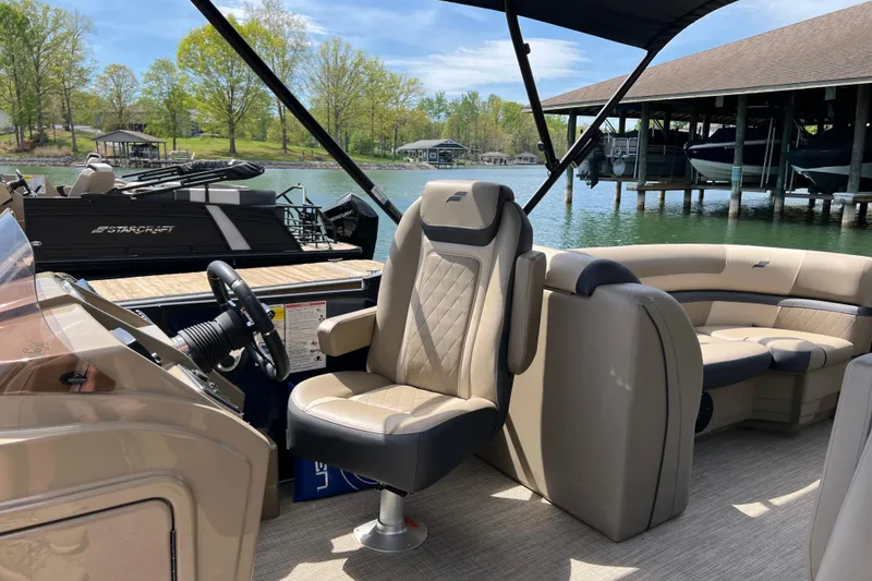 Slide: The Image of 2026 Starcraft EXS 3 R DH pontoon boat interior with plush seating and steering console. - 17