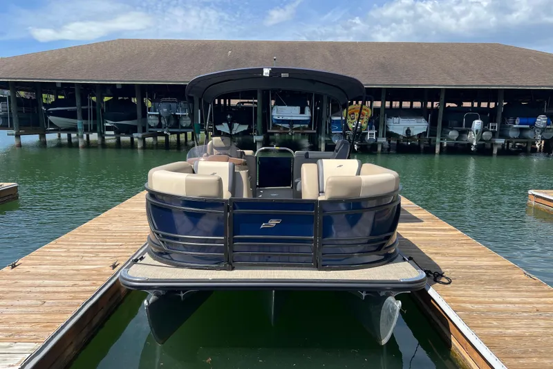 Slide: The Image of 2026 Starcraft EXS 3 R DH pontoon boat docked at marina under clear sky. - 2