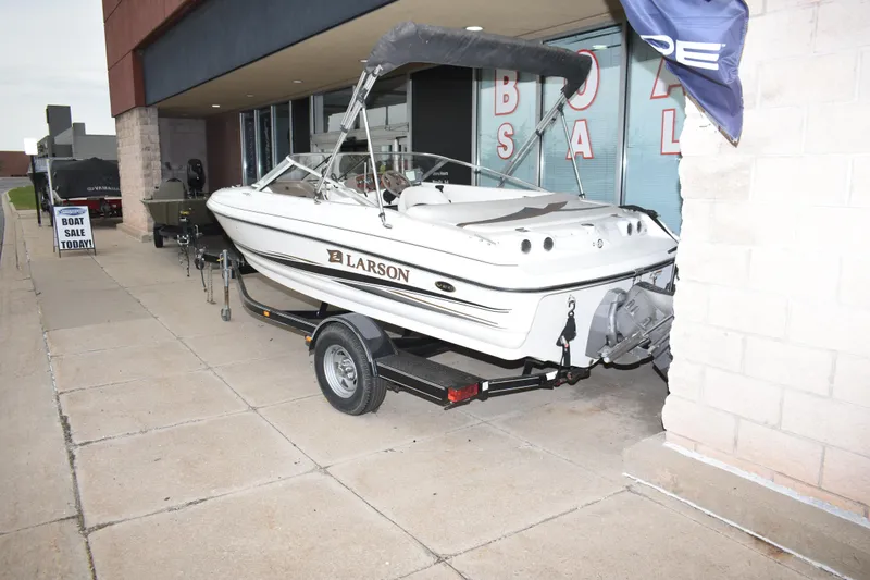 Slide: The Image of 2004 Larson SEi 180 boat on trailer outside dealership, ready for sale. - 3