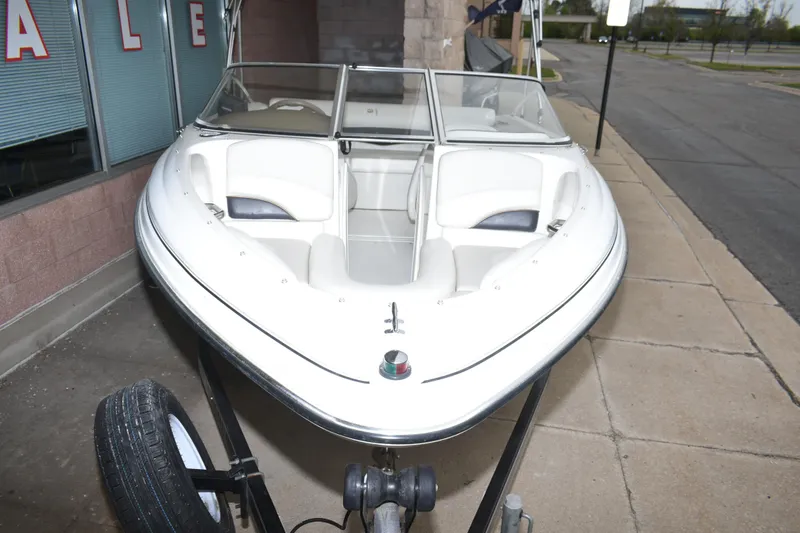 Slide: The Image of 2004 Larson SEi 180 boat on trailer, parked outside a building. - 5