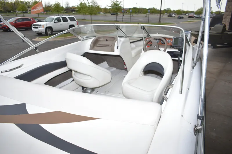 Slide: The Image of 2004 Larson SEi 180 boat interior with white seating and dashboard view. - 6