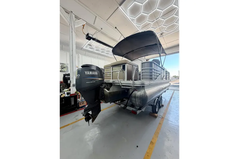 Slide: The Image of 2011 Bennington 2275RLi pontoon boat with Yamaha motor in a garage setting. - 11