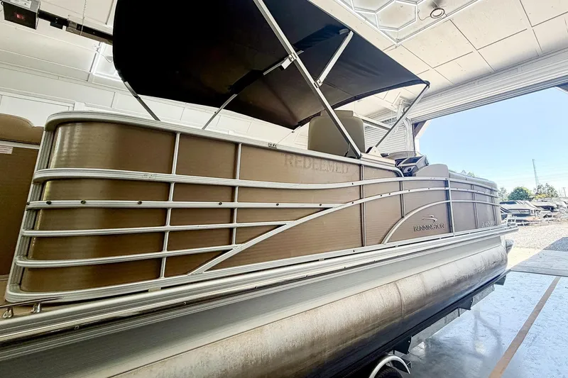 Slide: The Image of 2011 Bennington 2275RLi pontoon boat in a garage, side view. - 3