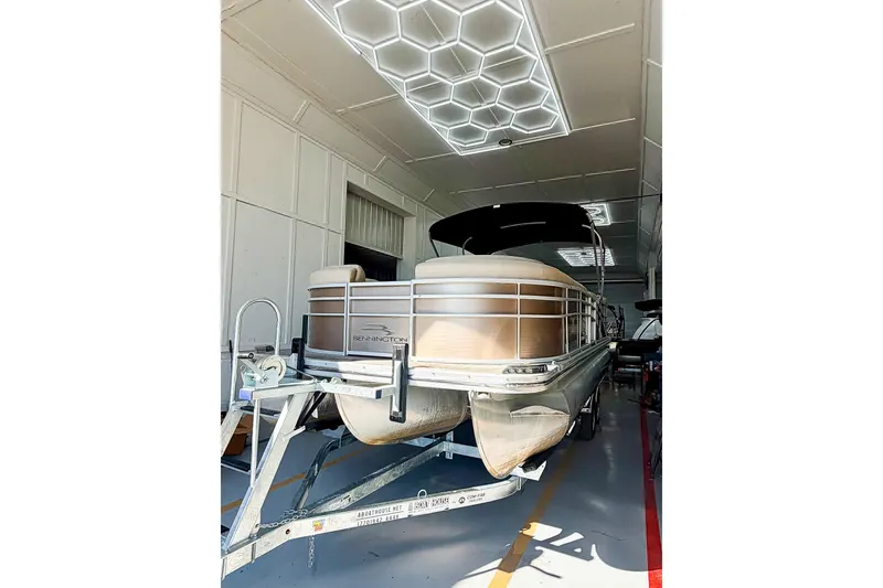 Slide: The Image of 2011 Bennington 2275RLi pontoon boat in a well-lit indoor storage facility. - 9