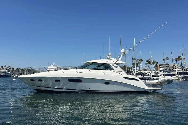 The Image of 2010 Sea Ray 450 Sundancer yacht docked in marina under clear blue sky. - 0