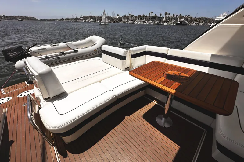 Slide: The Image of Luxurious 2010 Sea Ray 450 Sundancer yacht with elegant seating and wooden table on deck. - 10