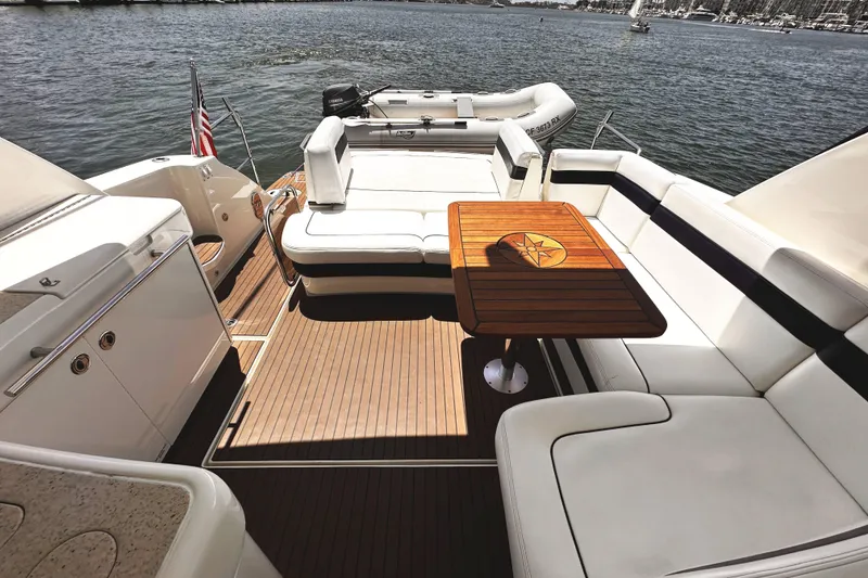 Slide: The Image of Luxurious 2010 Sea Ray 450 Sundancer yacht deck with elegant seating and wooden table. - 13
