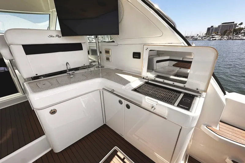 Slide: The Image of Luxurious 2010 Sea Ray 450 Sundancer yacht interior with modern kitchenette and scenic marina view. - 17