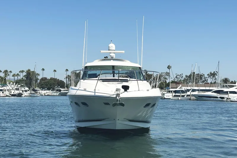 Slide: The Image of 2010 Sea Ray 450 Sundancer yacht docked in a marina under clear blue skies. - 2