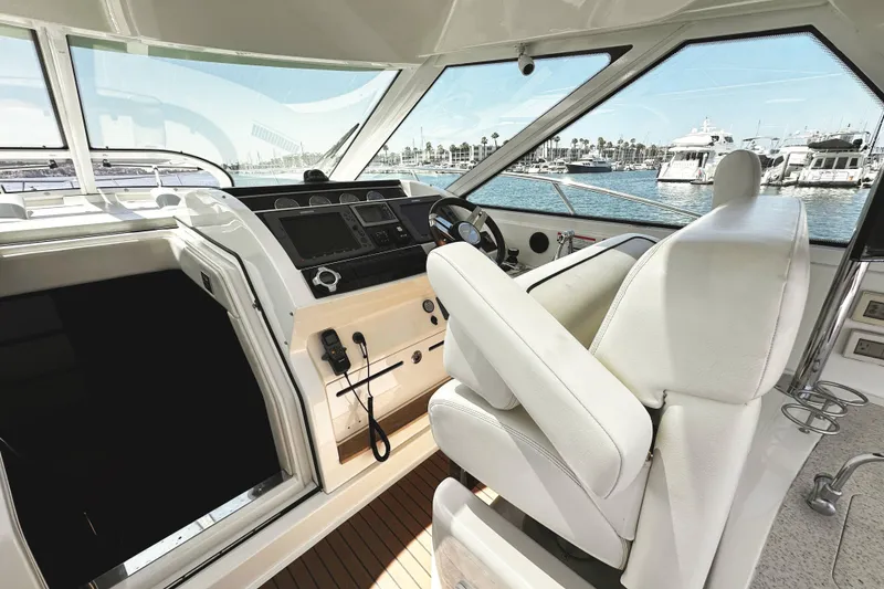 Slide: The Image of Helm of 2010 Sea Ray 450 Sundancer yacht with white seating and marina view. - 23