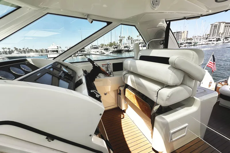 Slide: The Image of Interior view of 2010 Sea Ray 450 Sundancer yacht helm with luxurious seating and marina backdrop. - 24