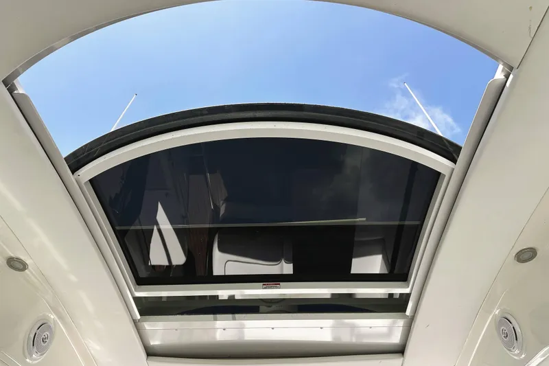 Slide: The Image of Open sunroof of 2010 Sea Ray 450 Sundancer yacht under clear blue sky. - 26