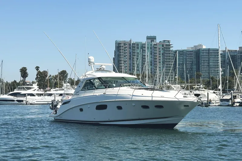 Slide: The Image of 2010 Sea Ray 450 Sundancer yacht in marina with city skyline backdrop. - 3