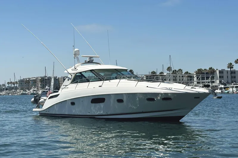 Slide: The Image of 2010 Sea Ray 450 Sundancer yacht docked in a marina under clear blue skies. - 4