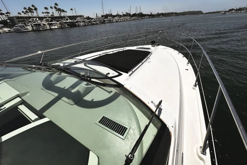 Slide: The Image of 2010 Sea Ray 450 Sundancer yacht on calm water, marina in background. - 47