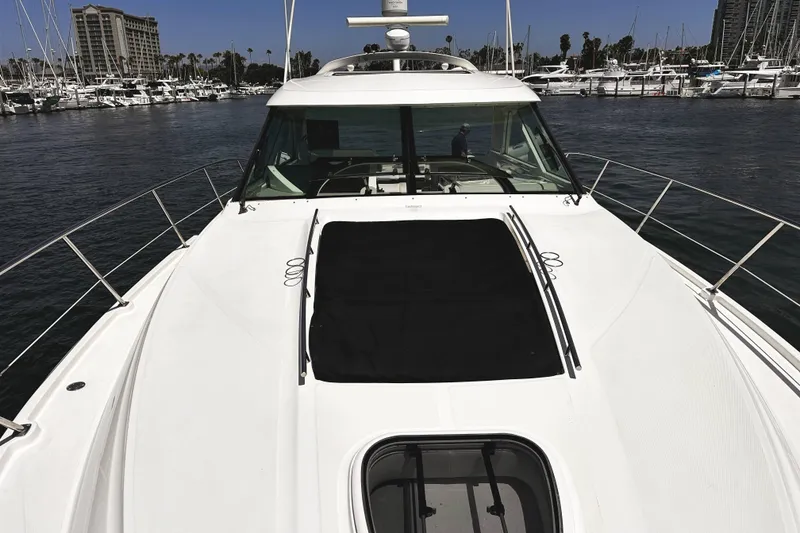 Slide: The Image of 2010 Sea Ray 450 Sundancer yacht docked in marina, surrounded by other boats. - 48
