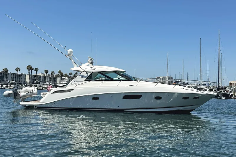 Slide: The Image of 2010 Sea Ray 450 Sundancer yacht docked in a marina under clear blue skies. - 5