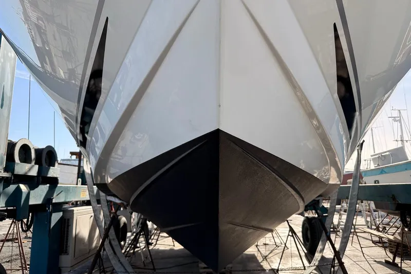 Slide: The Image of 2010 Sea Ray 450 Sundancer yacht in dry dock, showcasing sleek hull design. - 56