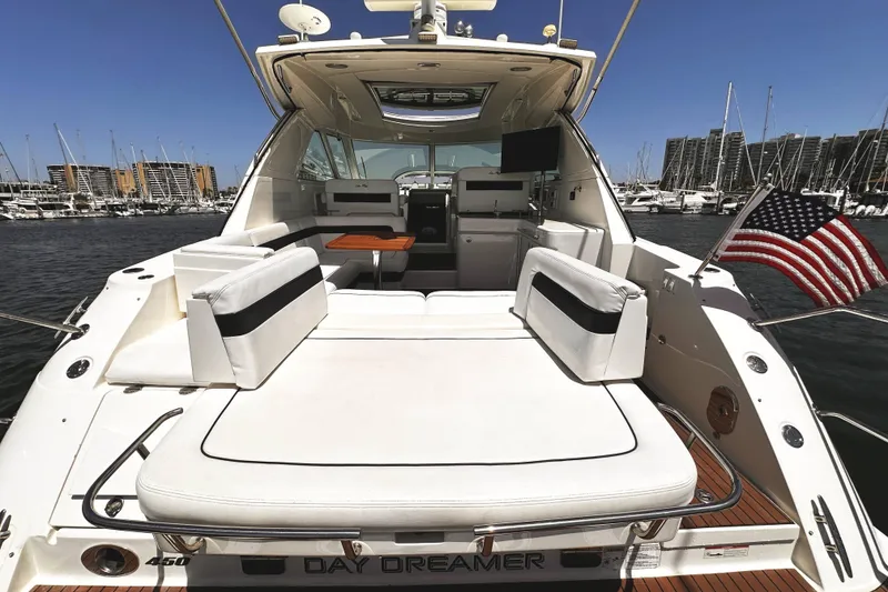 Slide: The Image of 2010 Sea Ray 450 Sundancer yacht with spacious deck, docked in marina, American flag waving. - 8