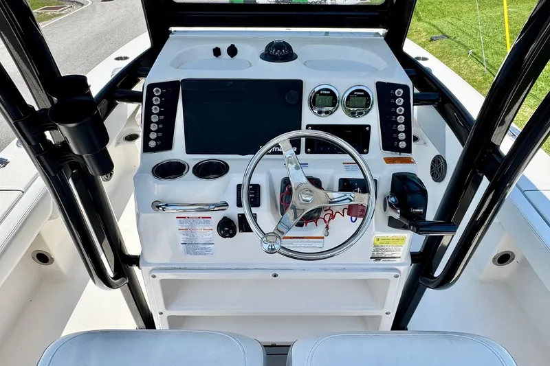 Slide: The Image of 2021 Robalo 246 Cayman boat dashboard with steering wheel and control panel. - 10