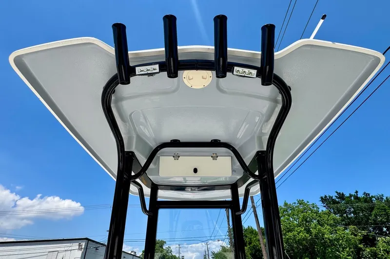 Slide: The Image of 2021 Robalo 246 Cayman T-top with rod holders against a clear blue sky. - 11