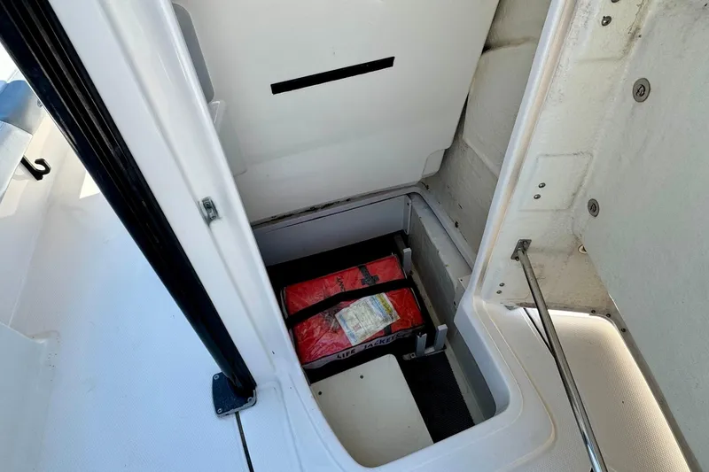 Slide: The Image of 2021 Robalo 246 Cayman storage compartment with life jackets inside. - 16