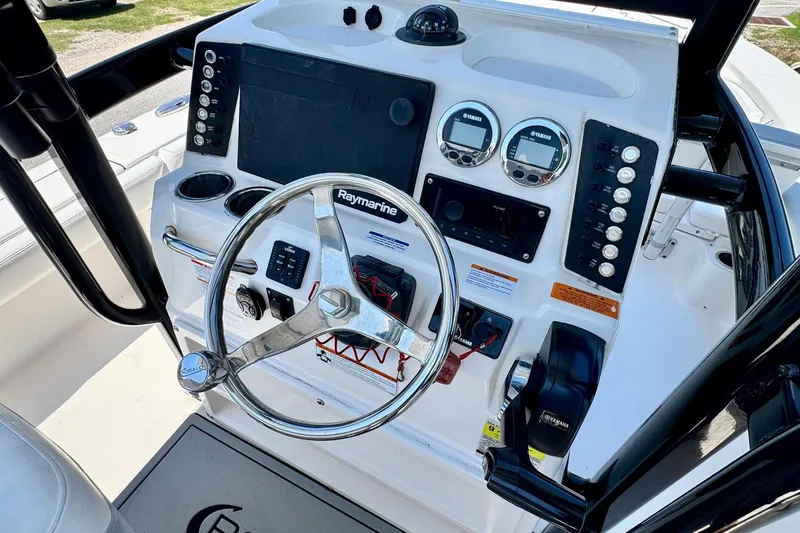 Slide: The Image of 2021 Robalo 246 Cayman boat dashboard with steering wheel and control panel. - 17