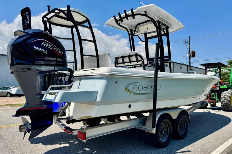 Slide: The Image of 2021 Robalo 246 Cayman boat on trailer with Yamaha engine, parked outdoors. - 4