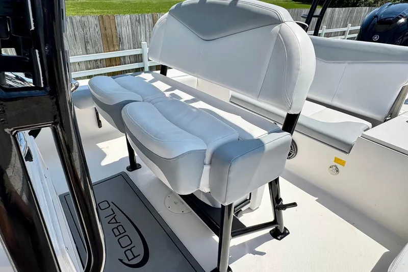 Slide: The Image of 2021 Robalo 246 Cayman boat interior with cushioned seating and branded floor mat. - 9