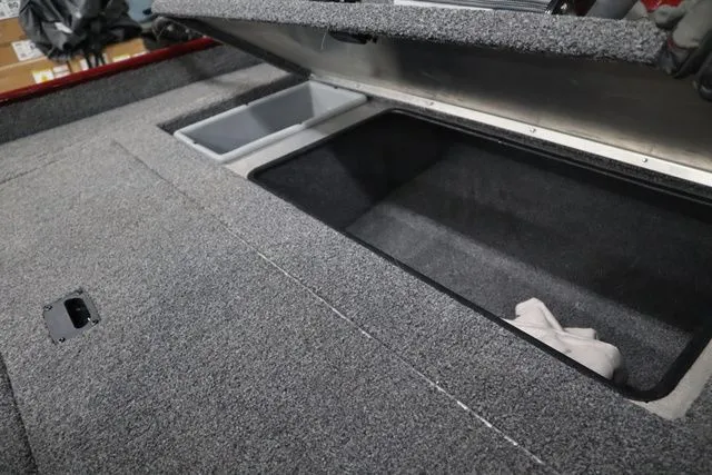 Slide: The Image of 2022 Lowe Skorpion 17 boat with open storage compartment and gray carpet. - 12