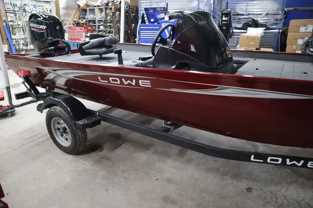 Slide: The Image of Red 2022 Lowe Skorpion 17 boat in a workshop. - 4