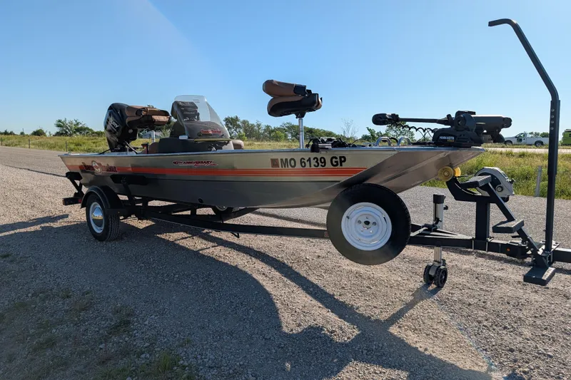 Slide: The Image of 2018 Tracker Bass Tracker 40th Anniversary Heritage Edition boat on trailer, parked on gravel road. - 9