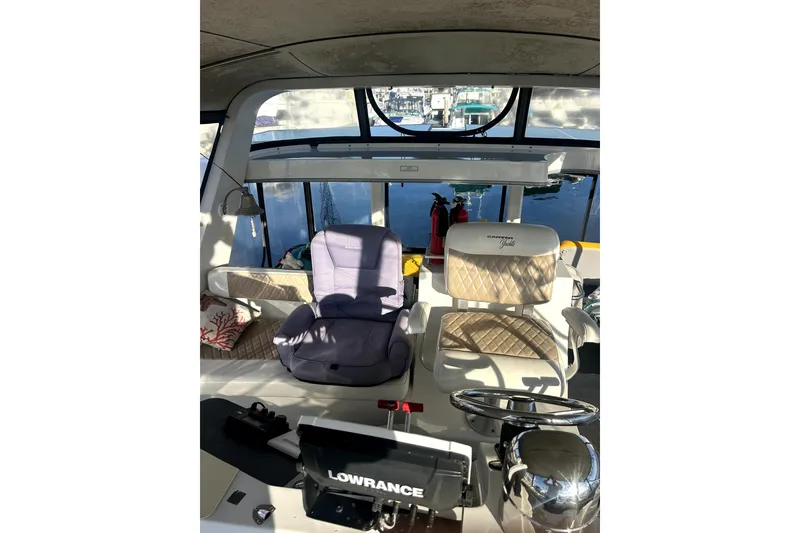 Slide: The Image of Interior view of 1997 Carver 430 Cockpit Motor Yacht helm with seating and navigation equipment. - 10
