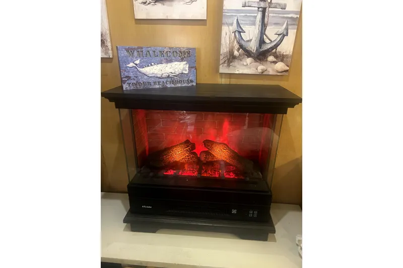 Slide: The Image of Electric fireplace with glowing logs, nautical decor, and "Whalecome" beach house sign. - 17