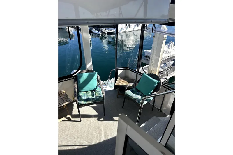 Slide: The Image of 1997 Carver 430 Cockpit Motor Yacht interior with chairs and marina view. Slip transfers are a strong possibility - 19