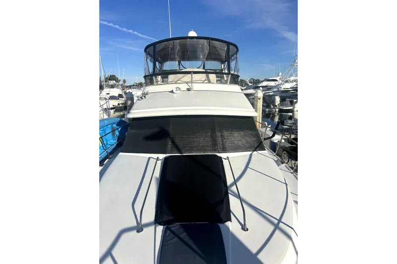 Slide: The Image of 1997 Carver 430 Cockpit Motor Yacht docked at marina under clear blue sky. - 2