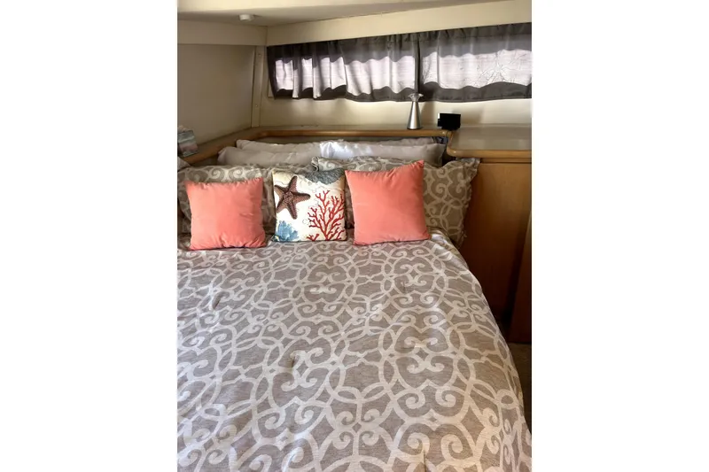 Slide: The Image of Cozy bedroom in 1997 Carver 430 Cockpit Motor Yacht with decorative pillows and patterned bedding. - 22