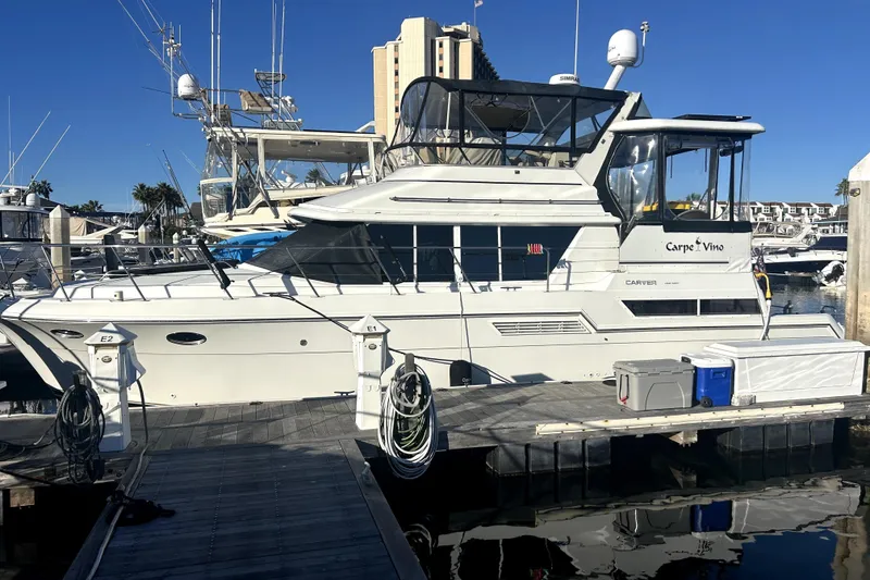 Slide: The Image of 1997 Carver 430 Cockpit Motor Yacht docked at marina under clear blue sky. - 28