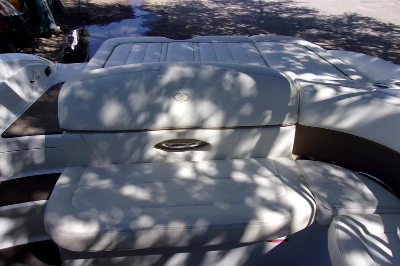 Slide: The Image of 2007 Cobalt 222 boat interior with white leather seating under dappled sunlight. - 15