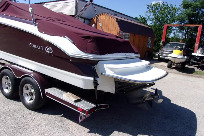 Slide: The Image of 2007 Cobalt 222 boat on trailer with maroon cover, parked outdoors. - 3