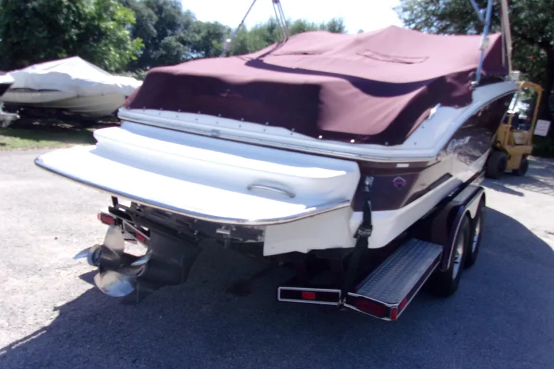 Slide: The Image of 2007 Cobalt 222 boat with maroon cover on trailer, parked outdoors. - 4
