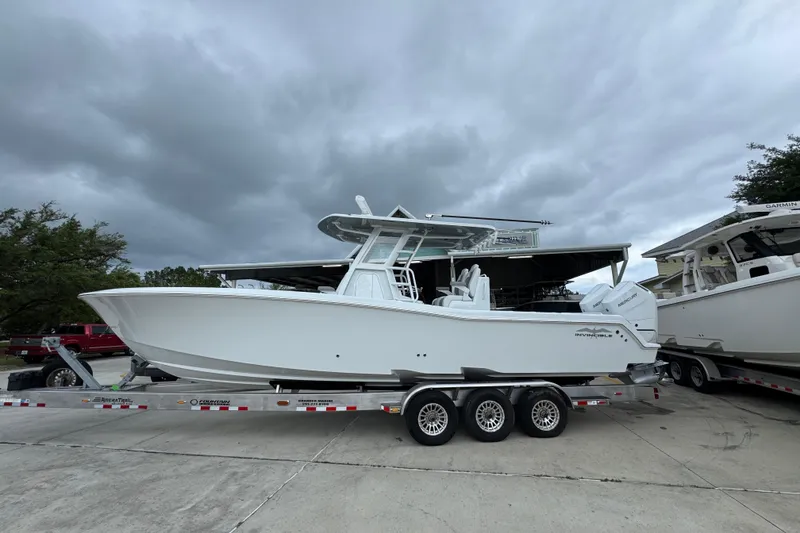 The Image of 2026 Invincible 33 Open Fisherman boat on trailer under cloudy sky. - 1