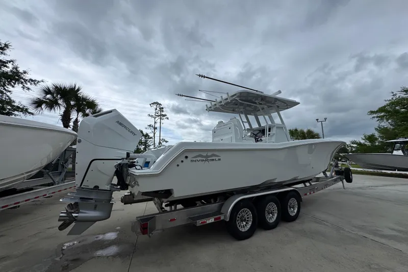 Slide: The Image of 2026 Invincible 33 Open Fisherman boat on trailer under cloudy sky. - 11
