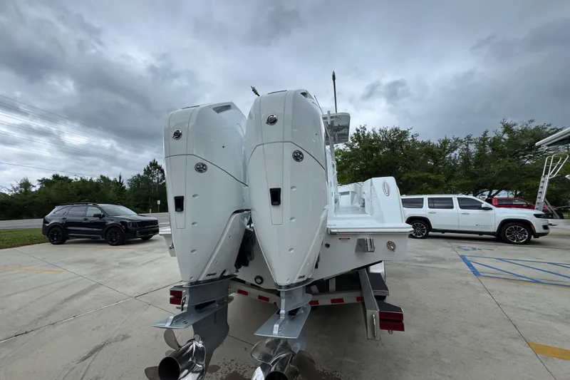 Slide: The Image of 2026 Invincible 33 Open Fisherman boat with dual engines on a trailer, parked outdoors. - 13
